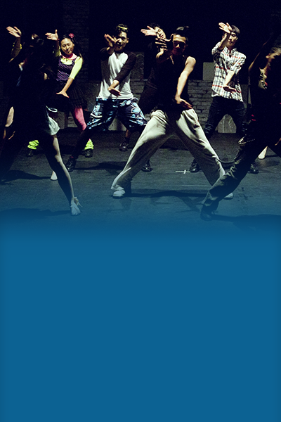 Spotlight on the Arts 400×600 Young performers on stage dancing in plain clothing